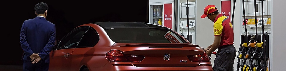 service attendant fuelling red bmw