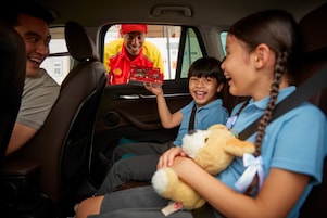 Family in car driving and smiling