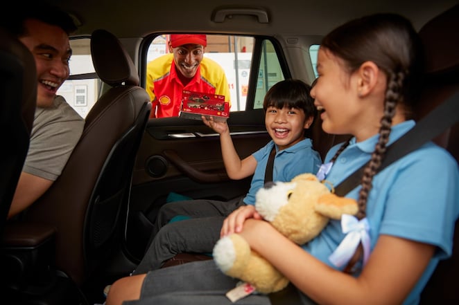 Family in car driving and smiling