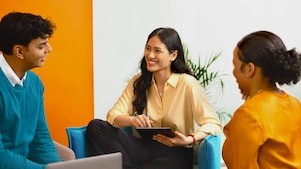 Three employees sitting and having a casual conversation