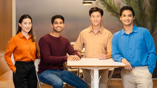 Team of four standing around a table in a modern workspace