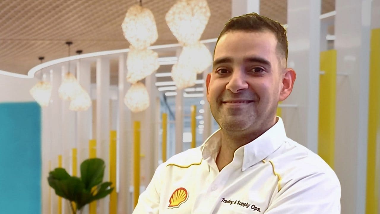 A man standing in front of the Shell Business Operations Manila office logo
