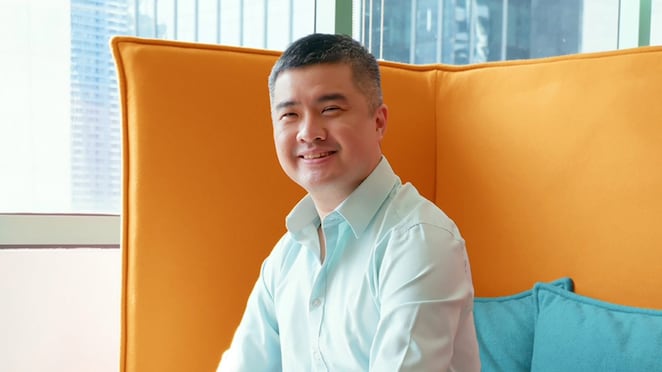 A man seated on a couch within an office setting