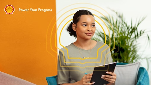 A woman smiling and looking elsewhere while holding an iPad in her hand