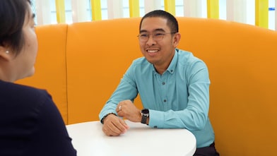 A man sharing a conversation with his colleague in an office