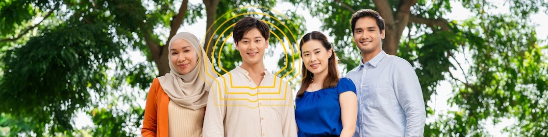 Four individuals standing outdoors with green trees in the background