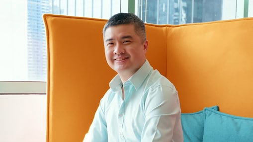 A man seated on a couch within an office setting