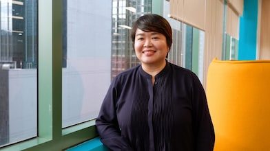 A woman standing by an office window