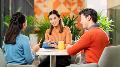 Team collaboration around laptop in modern office setting