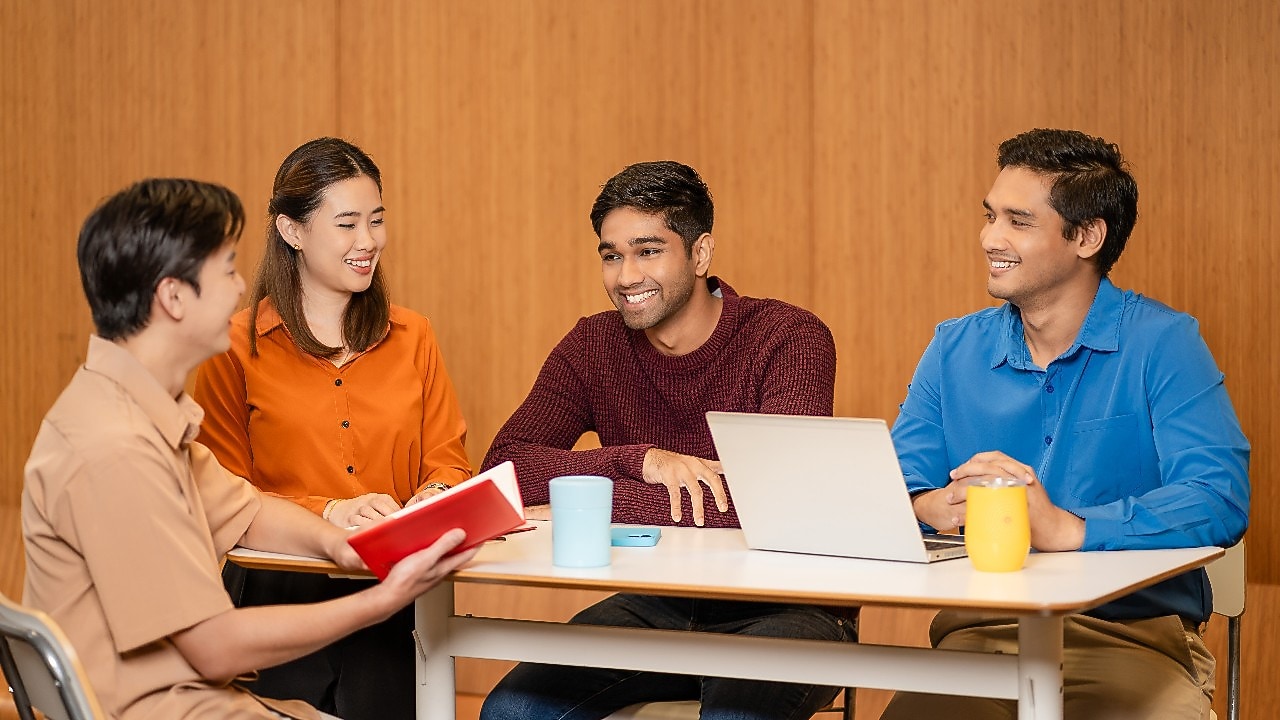 Four people sitting at a table engaged in discussion