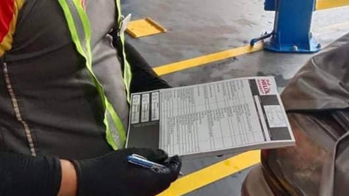 Shell technician checking the records of car