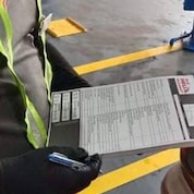 Shell technician checking the records of car