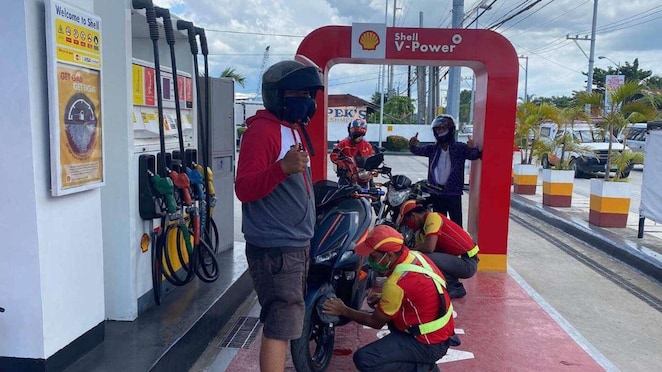 Man standing with his Bike on gas station