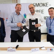 Two people shaking hands and other two people are standing