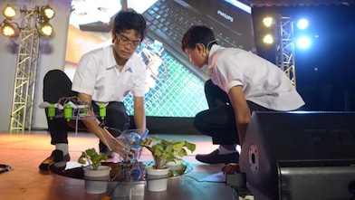 Team Agribon members, Rojan Alexei Granado and Jerico Wayne Bayod, showcase how their agricultural drone functions. The drone aims to reduce farm management costs, lessen the exposure of the farmers to pesticides, and reduce the risks when farming in sloped areas.