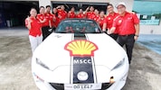 Shell employees posing with car