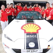 Shell employees posing with car