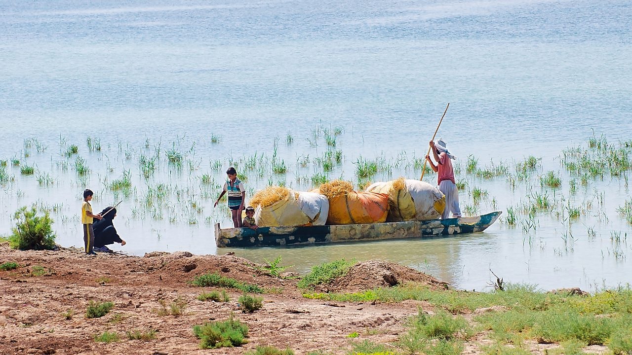 Local people cross the flooded Hawizeh Marshes, near the Majnoon project in Iraq
