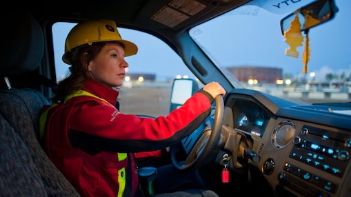 A lady wearing safety equipment driving a vehicle