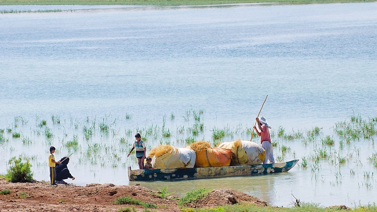 Local people cross the flooded Hawizeh Marshes, near the Majnoon project in Iraq