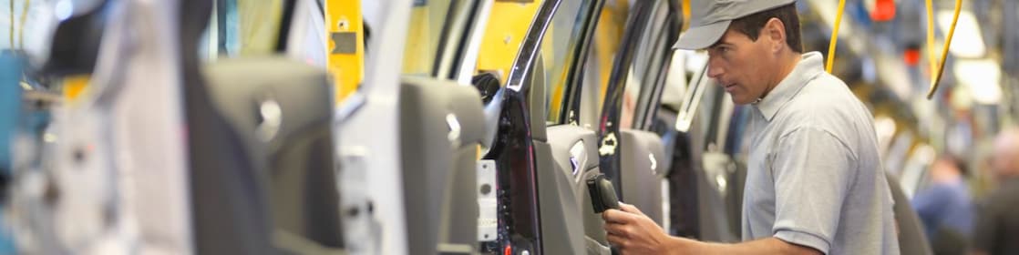 man holding wire looking at machine
