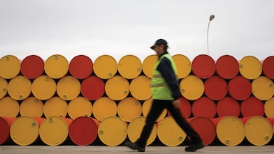 man walking barrels lubricants