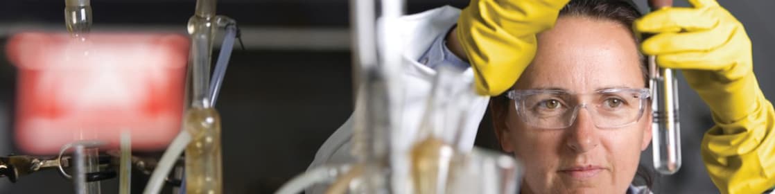 lady in safety goggles conducting a lab experiment