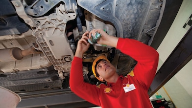 employee doing fitting of parts in car