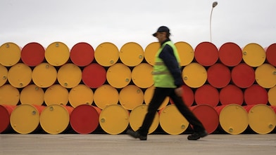 man walking barrels lubricants