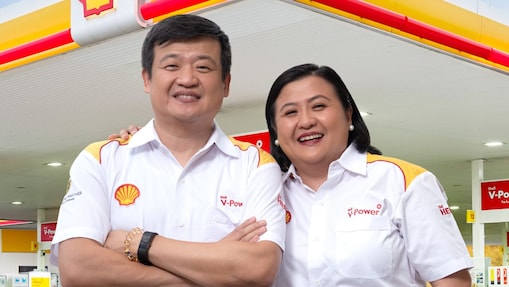 Man and woman standing in front of Shell station