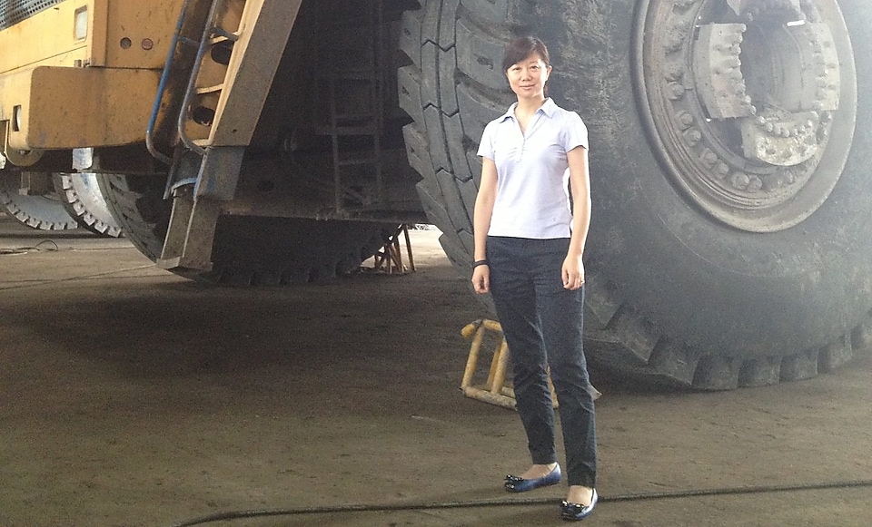 Jessica Zhu standing in front of large machinery.