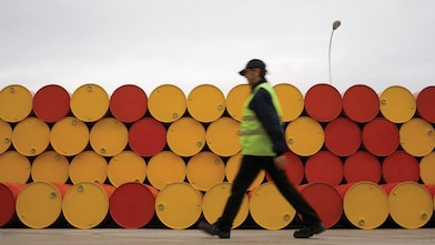 man walking barrels lubricants