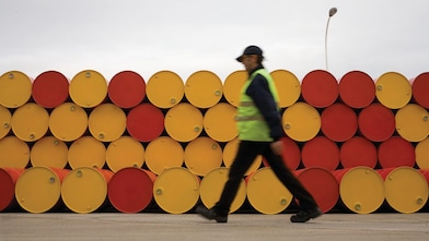 Man walking past barrels of Lubricants