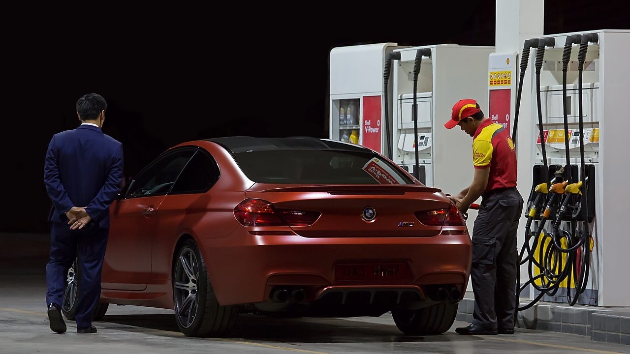 service attendant fuelling red bmw