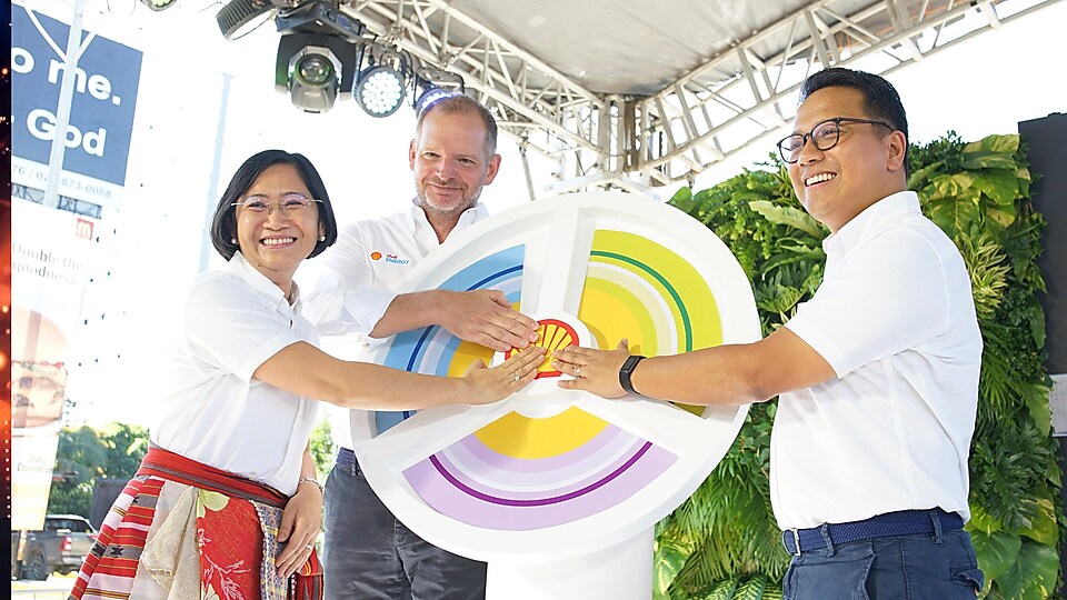 Three people holding Shell Logo