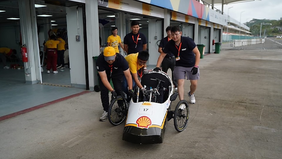 Beyond Borders cooperation is on display as students from Kazakhstan and the Philippines work together to push Avalon, UPHSD's vehicle, to technical inspection.