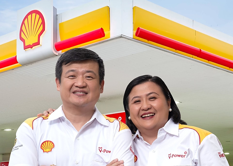 Man and woman standing in front of Shell station