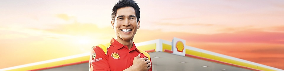 Shell attendant with hand on heart with Shell station in the background