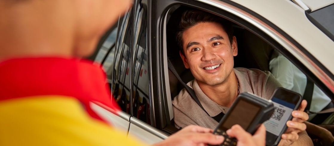 Driver and passenger laughing together on a scenic drive