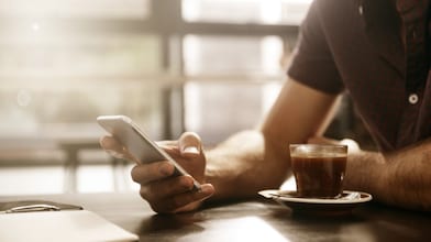 Man having a coffee looking at his smartphone