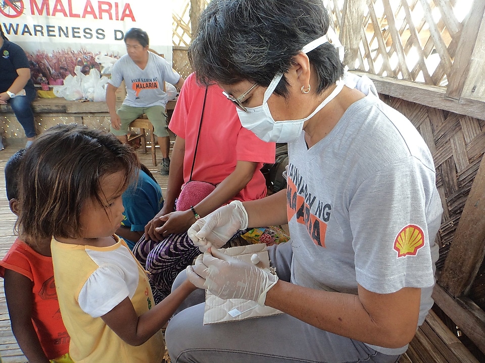 A malaria volunteer taking a blood sample